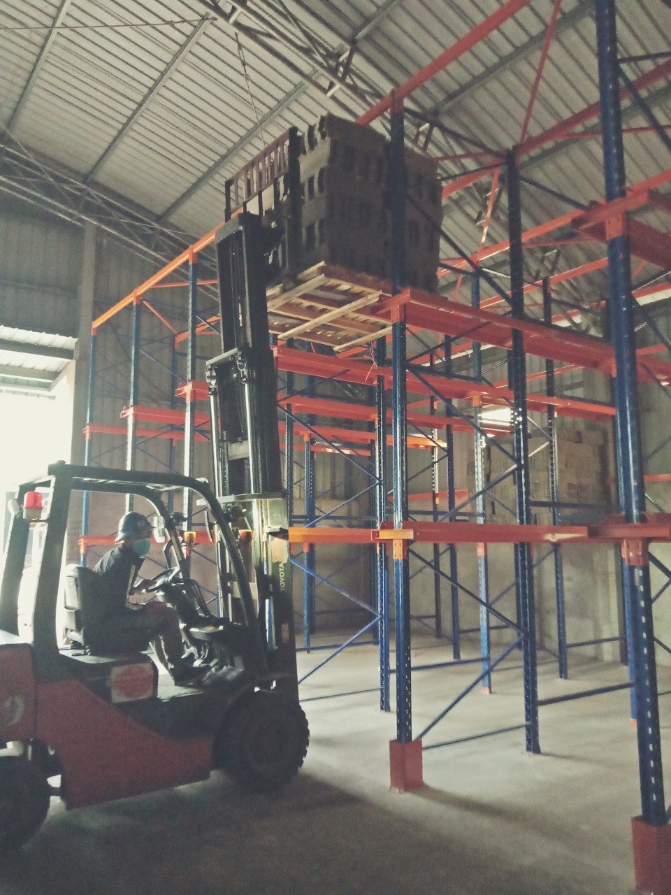 Xe nâng chạy vào làn kệ Drive-In để đặt pallet lên thanh ray đỡ tầng trên