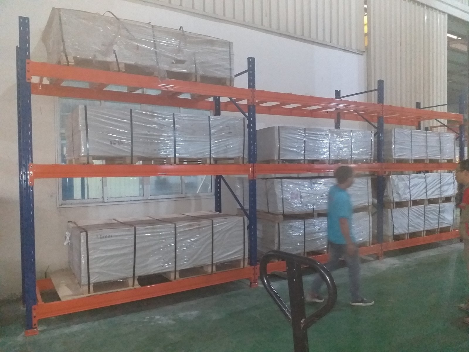 Mặt trước kệ Selective pallet với khung cột xanh, thanh beam cam và pallet hàng đặt trên từng tầng